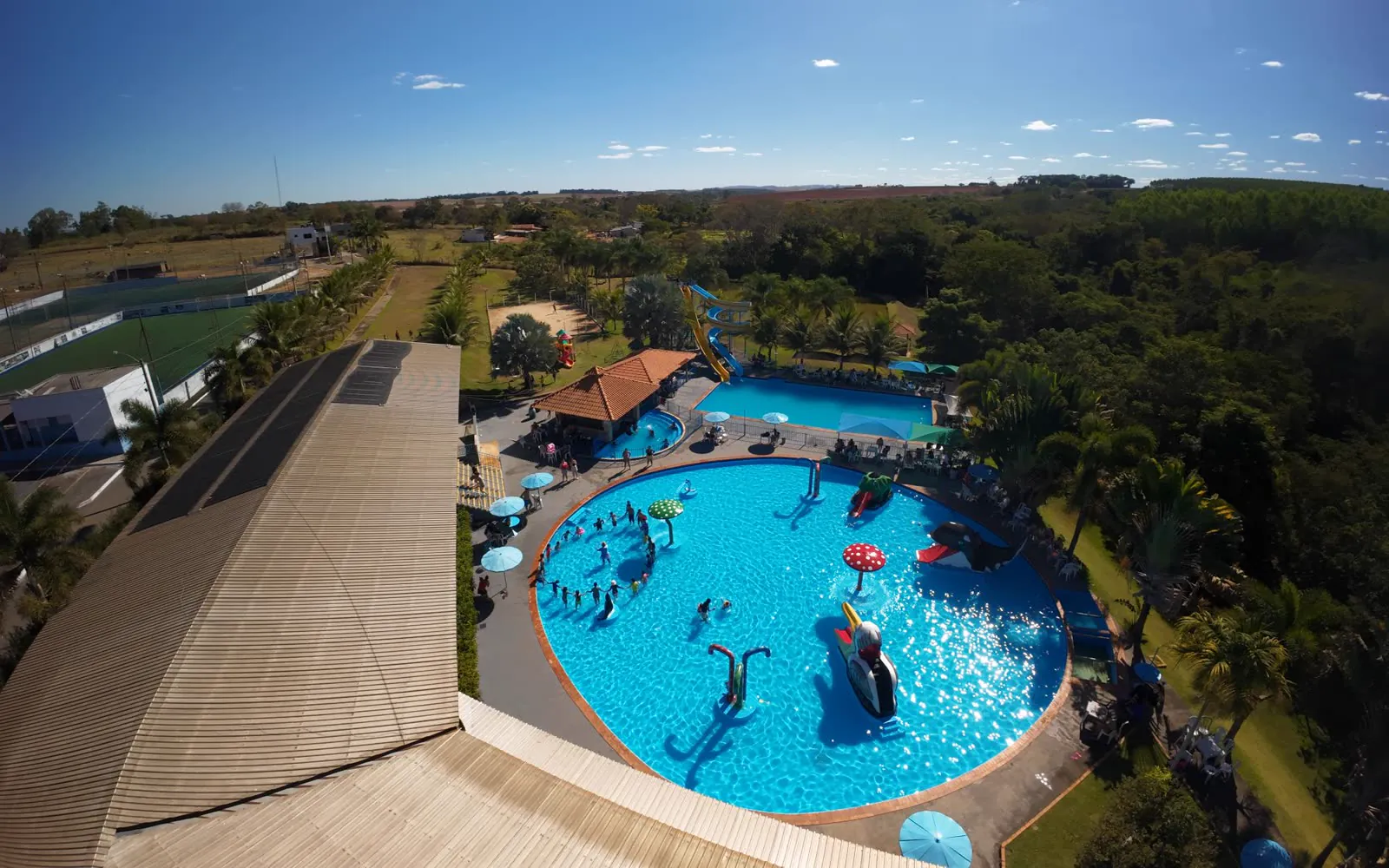 Piscina com a criançada fazendo ciranda, vista do alto